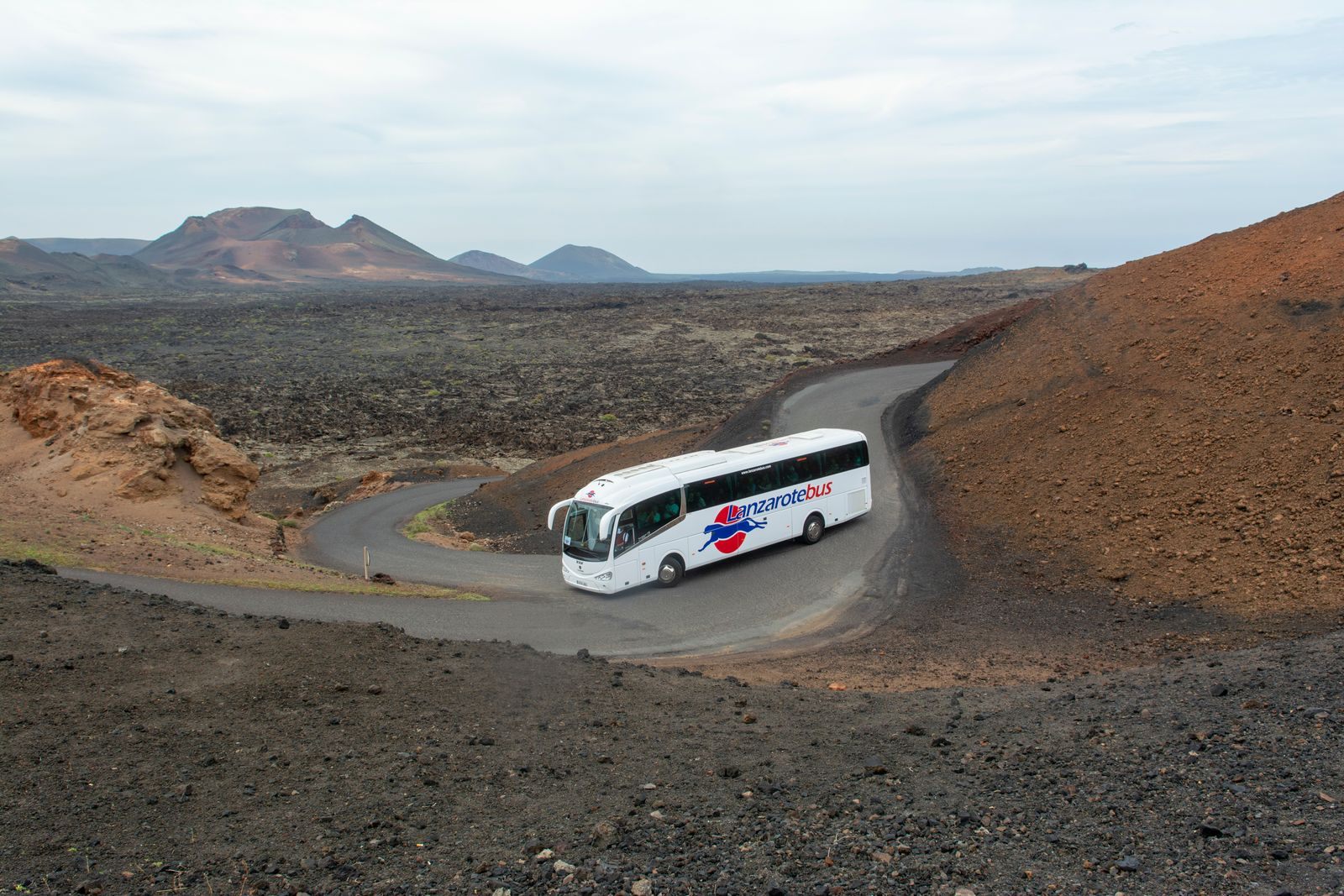 Tour coach driving through the volcanic landscape of Lanzarote, Canary Islands